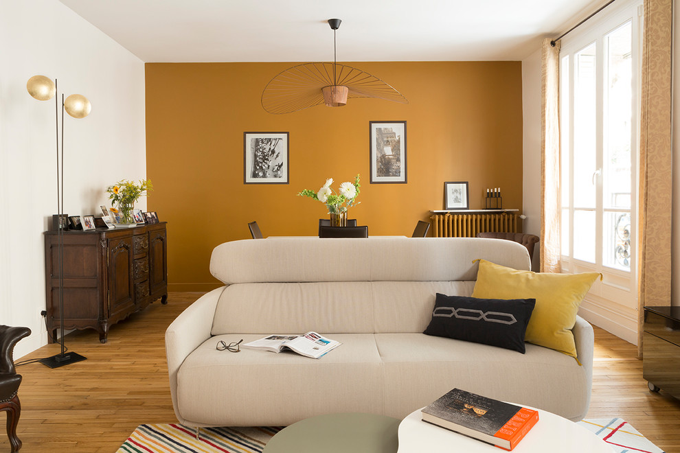 Inspiration for a mid-sized transitional enclosed light wood floor and beige floor family room remodel in Paris with orange walls