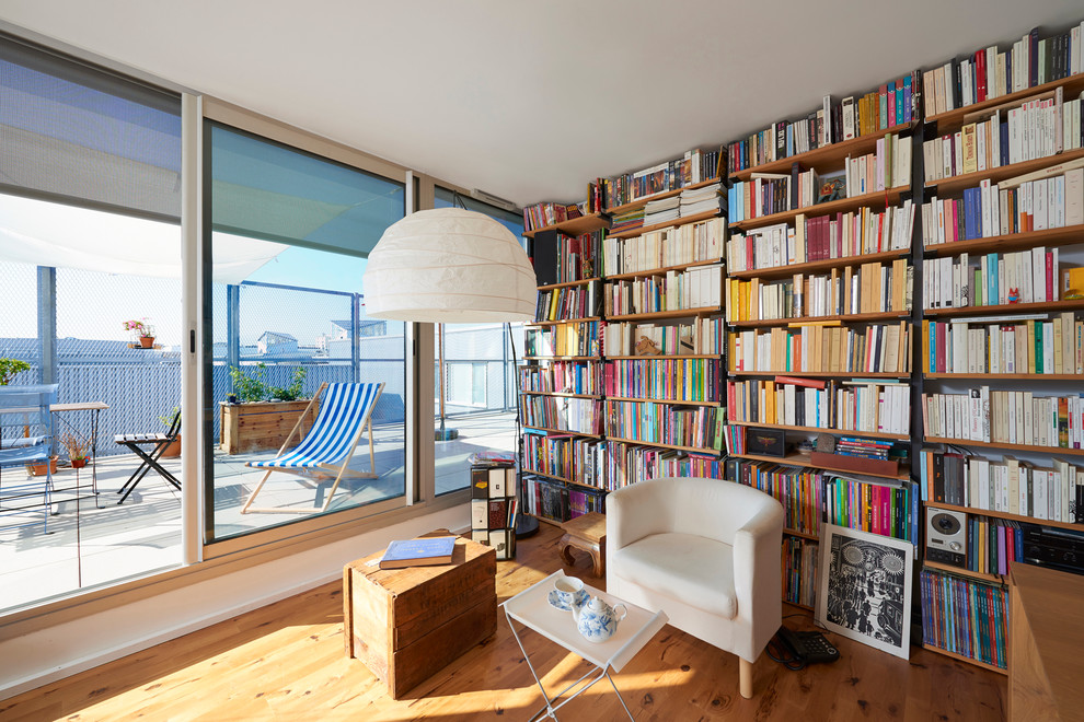 Cette photo montre une salle de séjour chic de taille moyenne et fermée avec une bibliothèque ou un coin lecture et parquet clair.