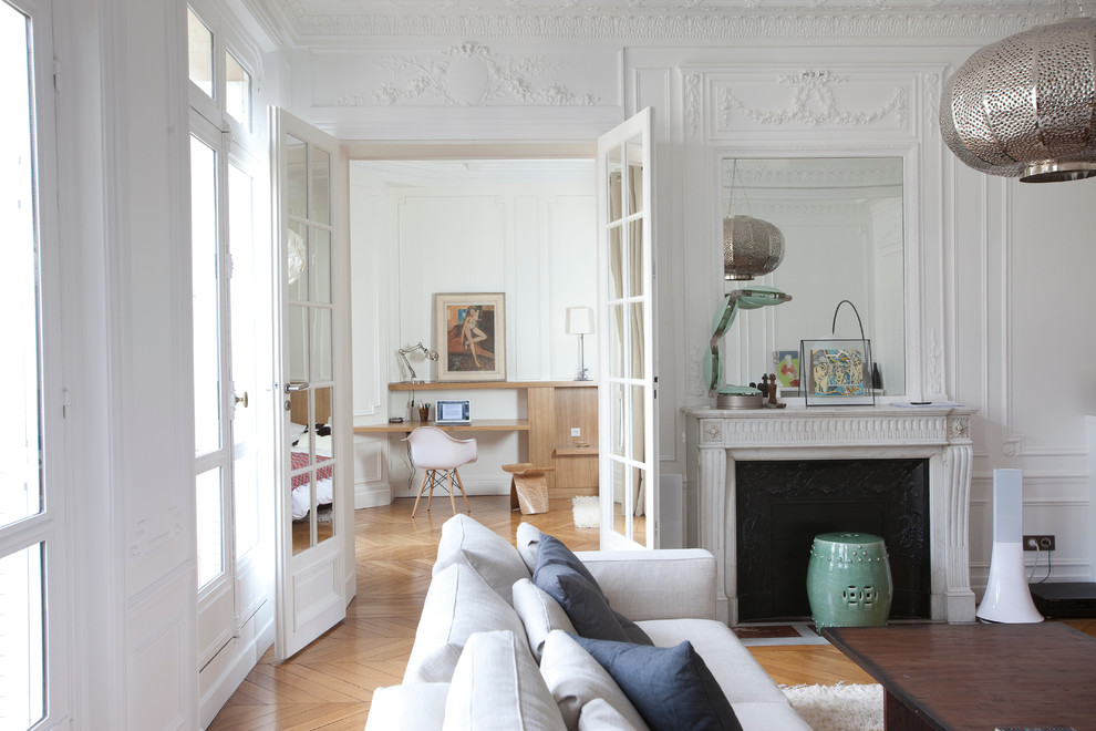 Immagine di un soggiorno contemporaneo chiuso con pareti bianche, pavimento in legno massello medio e camino classico