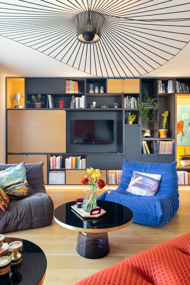 Inspiration pour une grande salle de séjour minimaliste ouverte avec une bibliothèque ou un coin lecture, un mur blanc, parquet clair, un téléviseur dissimulé et un sol marron.