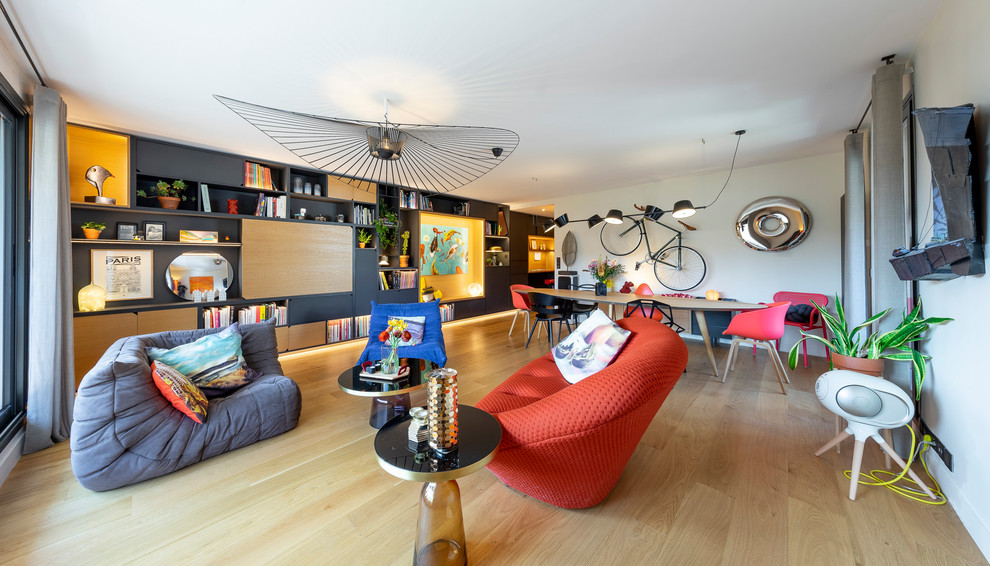 Esempio di un grande soggiorno minimalista aperto con libreria, pareti bianche, parquet chiaro, TV nascosta e pavimento marrone