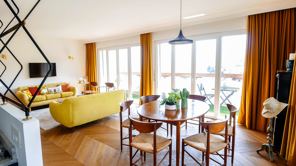 Imagen de sala de estar abierta escandinava de tamaño medio con paredes blancas, suelo de madera clara, televisor colgado en la pared y suelo beige