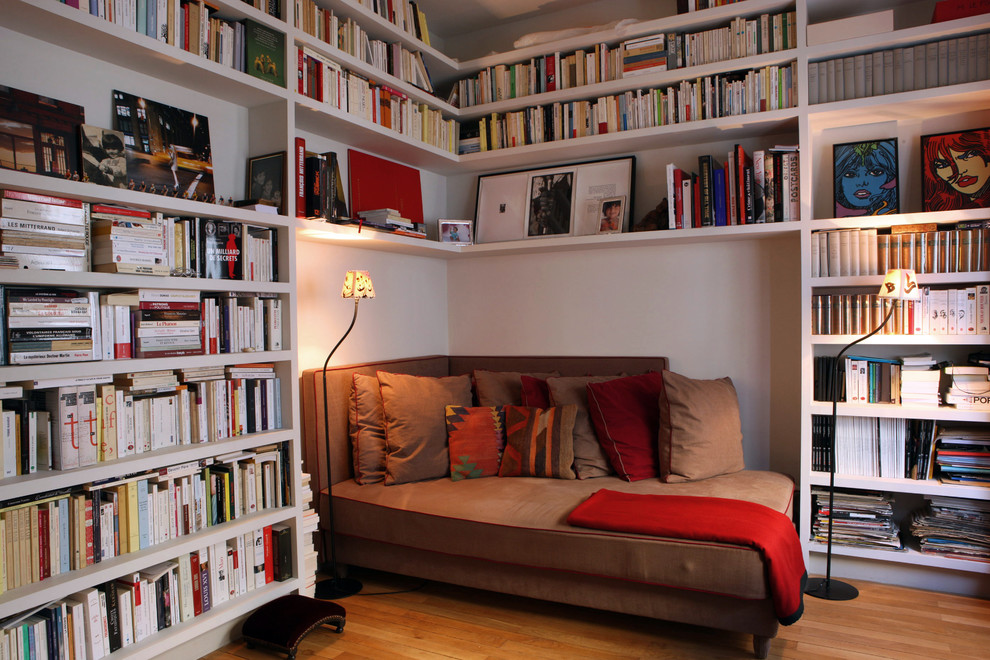 Inspiration för ett mellanstort funkis allrum, med ett bibliotek, vita väggar och mellanmörkt trägolv
