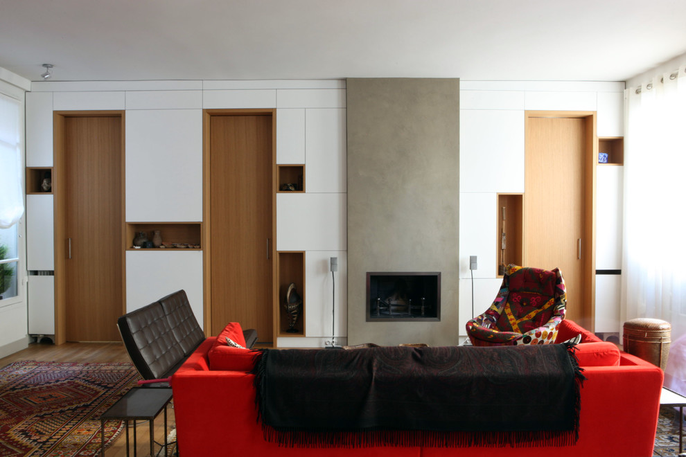 Großes, Fernseherloses, Offenes Modernes Wohnzimmer mit weißer Wandfarbe, braunem Holzboden und Kamin in Paris