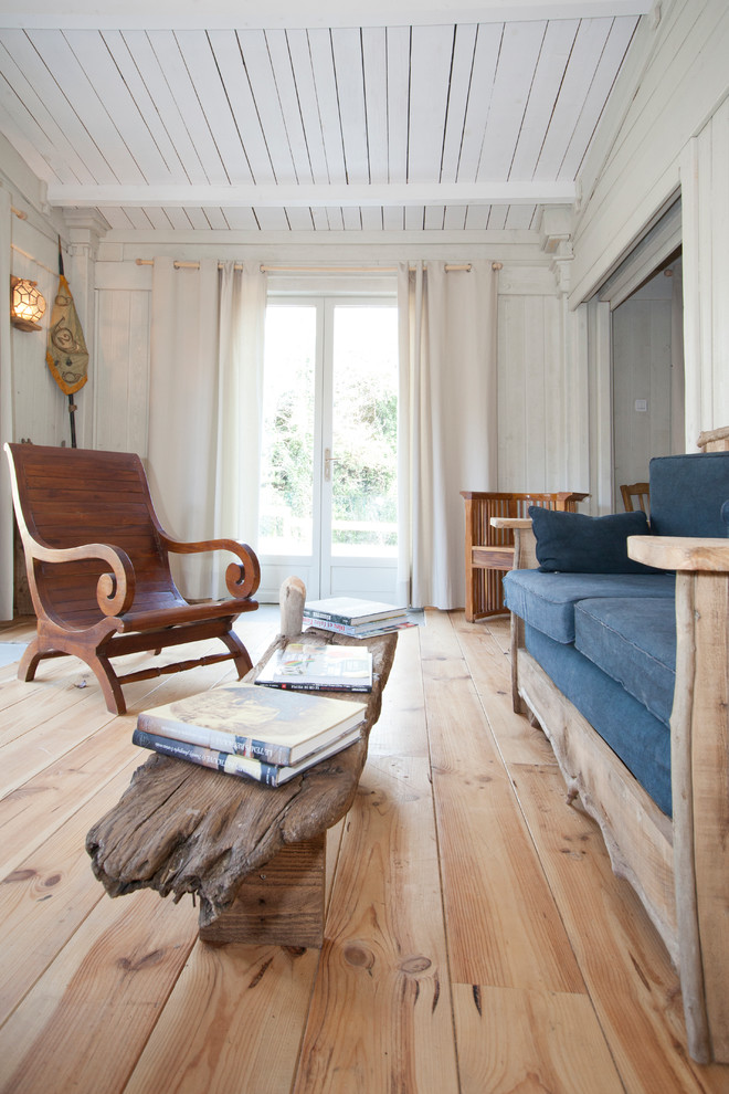 Esempio di un soggiorno bohémian di medie dimensioni e chiuso con pareti bianche e pavimento in legno massello medio