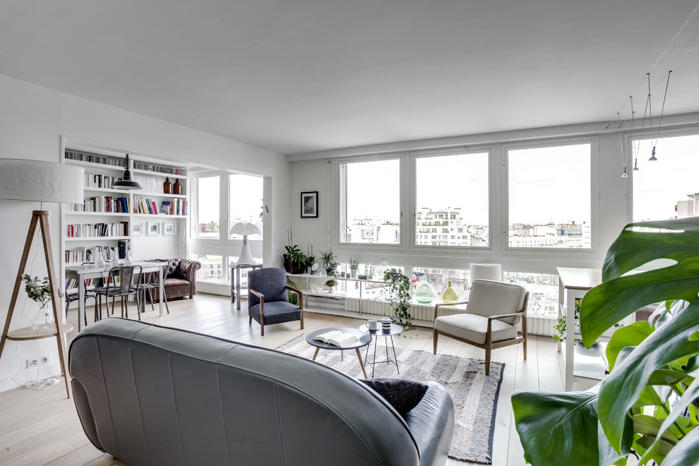 Imagen de sala de estar abierta escandinava con paredes blancas, suelo de madera clara y suelo beige