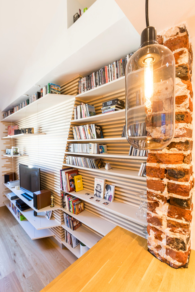 Example of a small trendy open concept light wood floor and brown floor family room library design in Paris with white walls, no fireplace and a tv stand