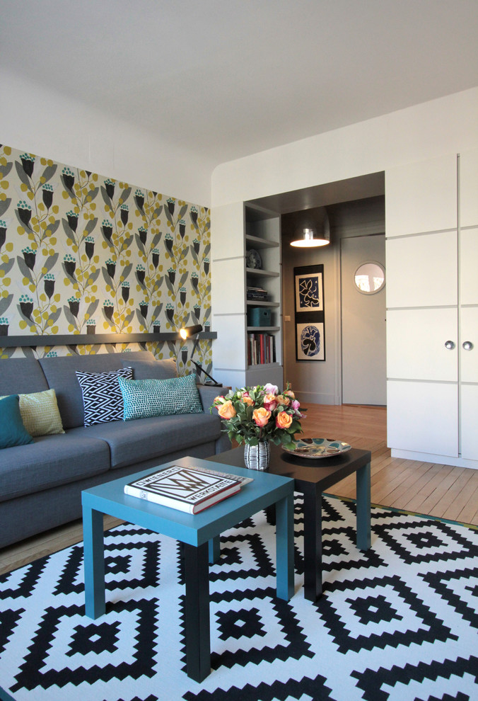 Modelo de sala de estar cerrada contemporánea de tamaño medio sin chimenea y televisor con paredes multicolor y suelo de madera en tonos medios