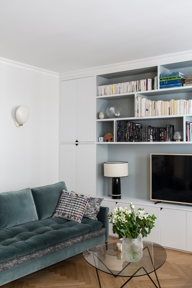 Источник вдохновения для домашнего уюта: маленькая гостиная комната в скандинавском стиле с белыми стенами, светлым паркетным полом, с книжными шкафами и полками, отдельно стоящим телевизором и бежевым полом для на участке и в саду