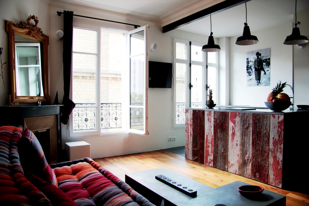 Example of an urban dark wood floor family room design in Paris with a corner fireplace