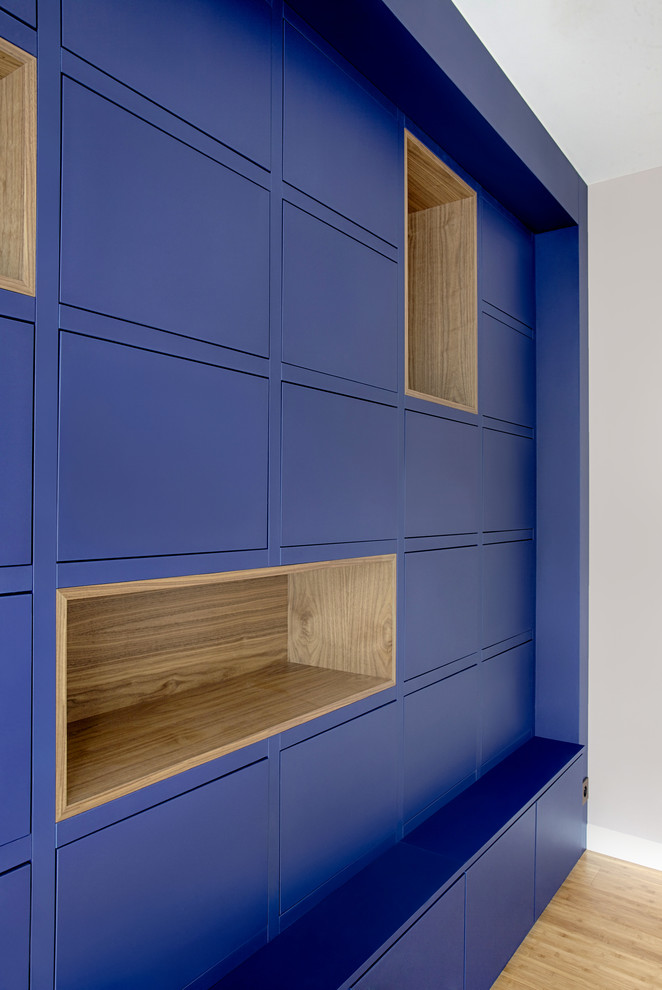 Источник вдохновения для домашнего уюта: огромная изолированная гостиная комната в современном стиле с с книжными шкафами и полками, синими стенами, полом из бамбука и коричневым полом без камина, телевизора