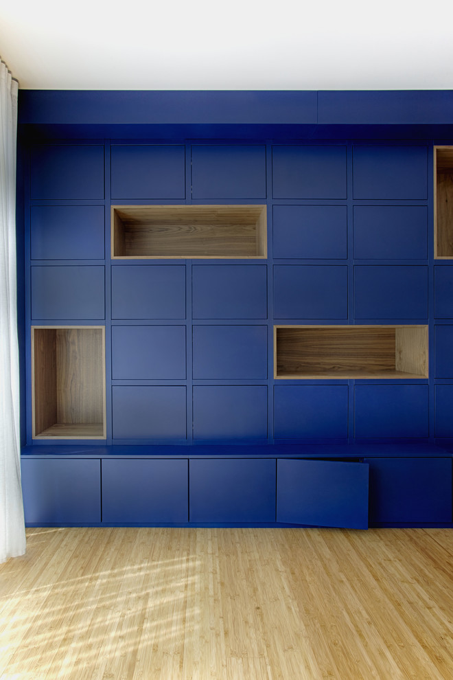 Inspiration för ett mycket stort funkis avskilt allrum, med ett bibliotek, blå väggar, bambugolv och brunt golv