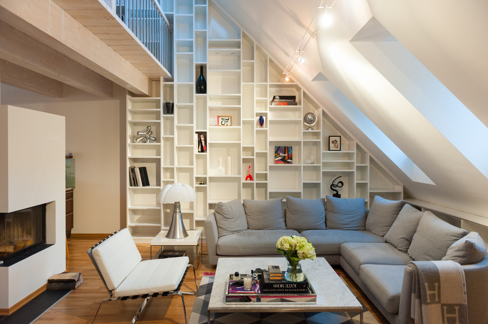 Ispirazione per un soggiorno design aperto con libreria, pareti bianche, camino ad angolo e nessuna TV