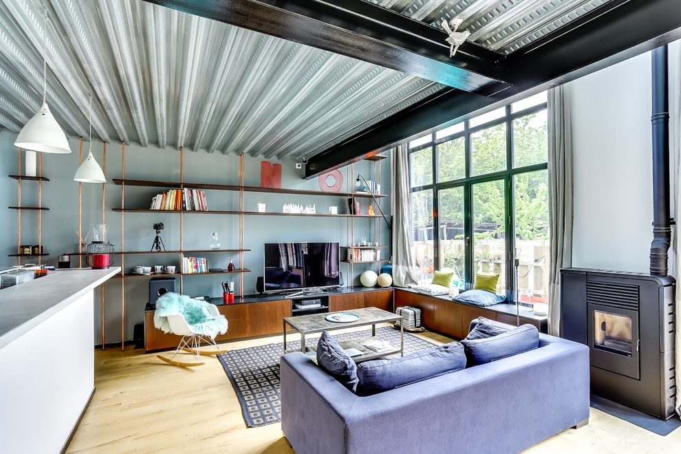 Esempio di un soggiorno industriale di medie dimensioni con parquet chiaro, TV autoportante, libreria e pareti multicolore