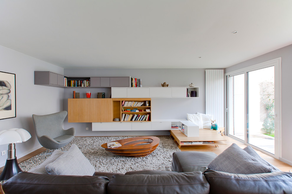 Стильный дизайн: изолированная гостиная комната среднего размера в современном стиле с серыми стенами и светлым паркетным полом - последний тренд