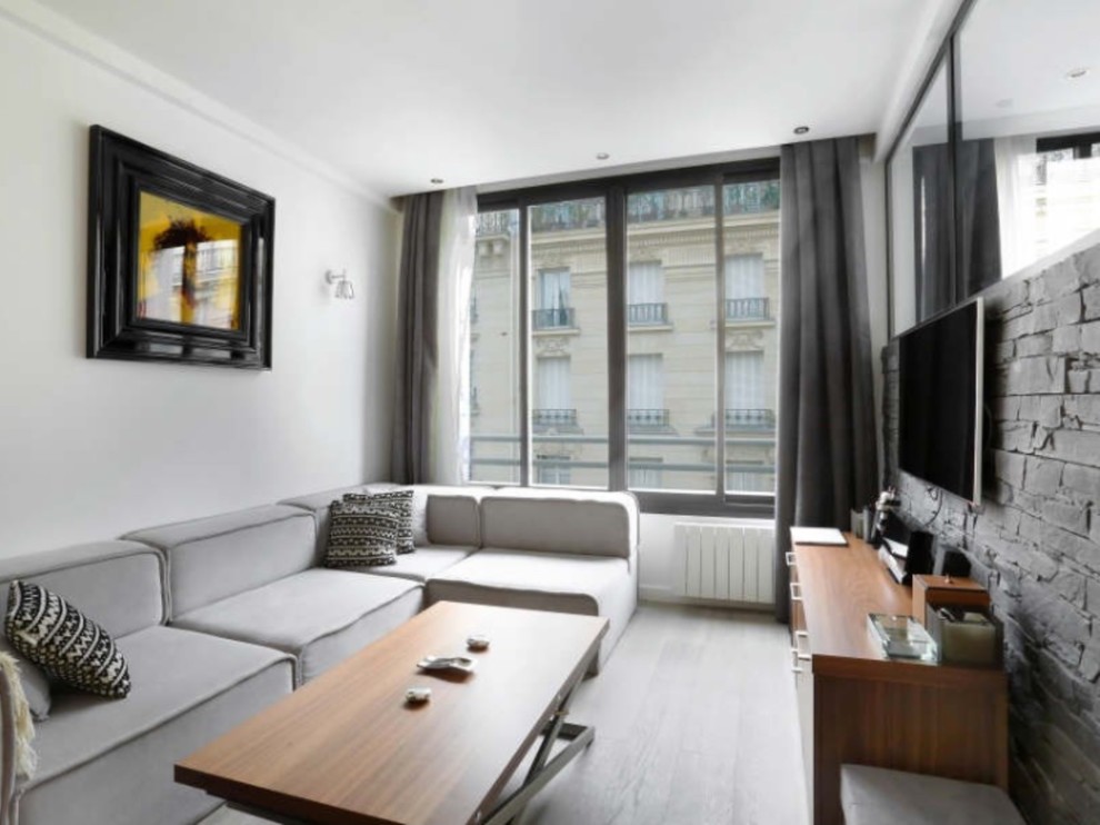 Kleines, Abgetrenntes Modernes Wohnzimmer ohne Kamin mit weißer Wandfarbe, hellem Holzboden, TV-Wand und grauem Boden in Paris