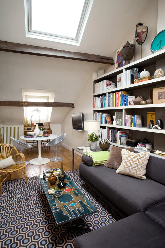 Diseño de sala de estar con biblioteca ecléctica de tamaño medio con paredes blancas, suelo de madera en tonos medios y televisor colgado en la pared