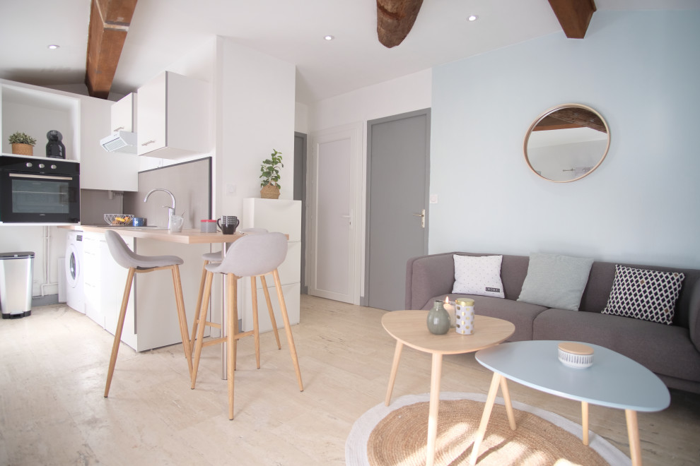Idee per un piccolo soggiorno scandinavo con pareti blu e pavimento in travertino