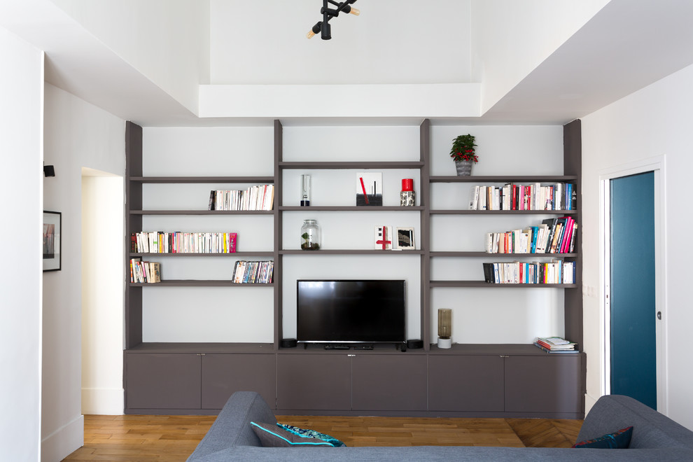 Modelo de sala de estar abierta contemporánea de tamaño medio sin chimenea con paredes blancas, suelo de madera en tonos medios, televisor independiente y suelo beige