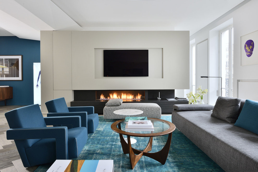 Ejemplo de sala de estar abierta contemporánea grande con paredes blancas, chimenea lineal, televisor colgado en la pared y alfombra