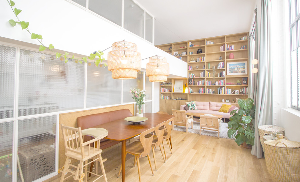 Exemple d'une salle de séjour mansardée ou avec mezzanine tendance de taille moyenne avec une bibliothèque ou un coin lecture, un mur blanc, parquet clair et aucun téléviseur.