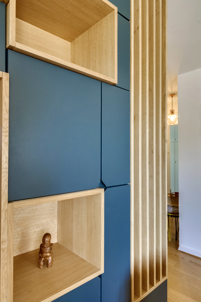 Esempio di un soggiorno scandinavo di medie dimensioni e aperto con libreria, pareti bianche, parquet chiaro, parete attrezzata e pavimento beige
