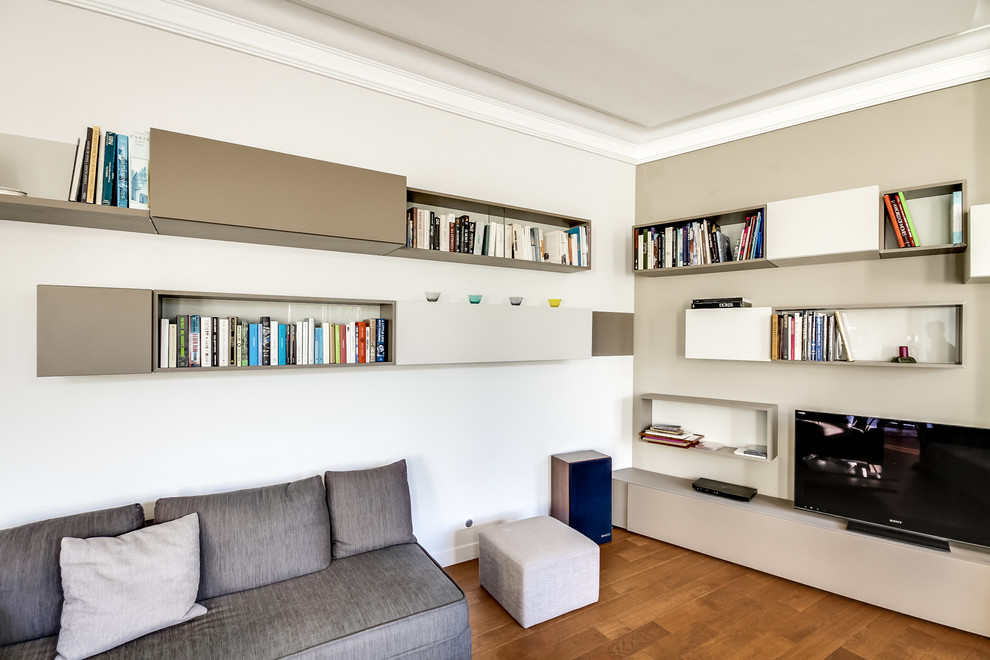 Idéer för ett mellanstort modernt allrum, med ett bibliotek, vita väggar, mellanmörkt trägolv och en fristående TV