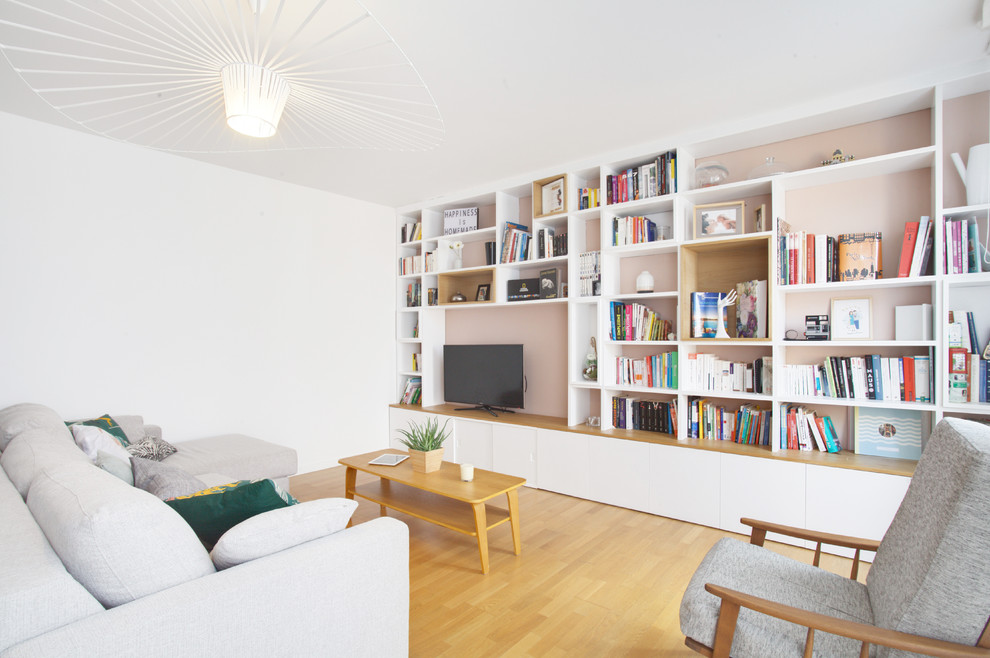 Aménagement d'une salle de séjour contemporaine avec un mur blanc, un sol en bois brun, un téléviseur encastré et un sol marron.