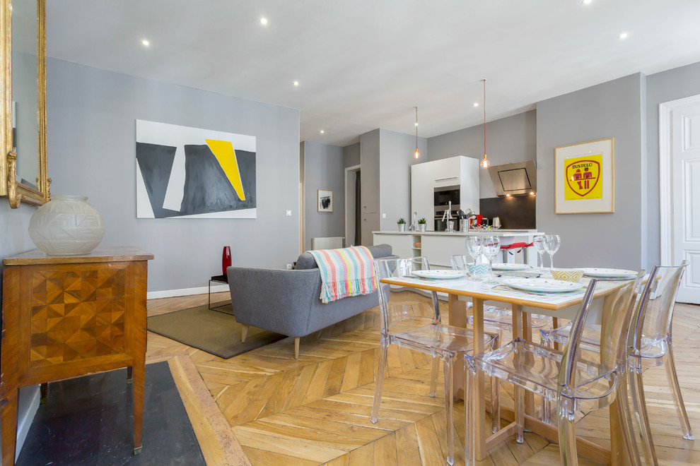 Diseño de sala de estar abierta actual con paredes grises y suelo de madera en tonos medios