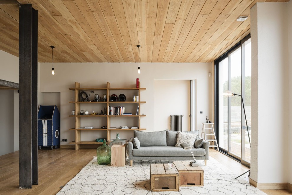 Aménagement d'une salle de séjour contemporaine avec un mur blanc, un sol en bois brun et un sol marron.