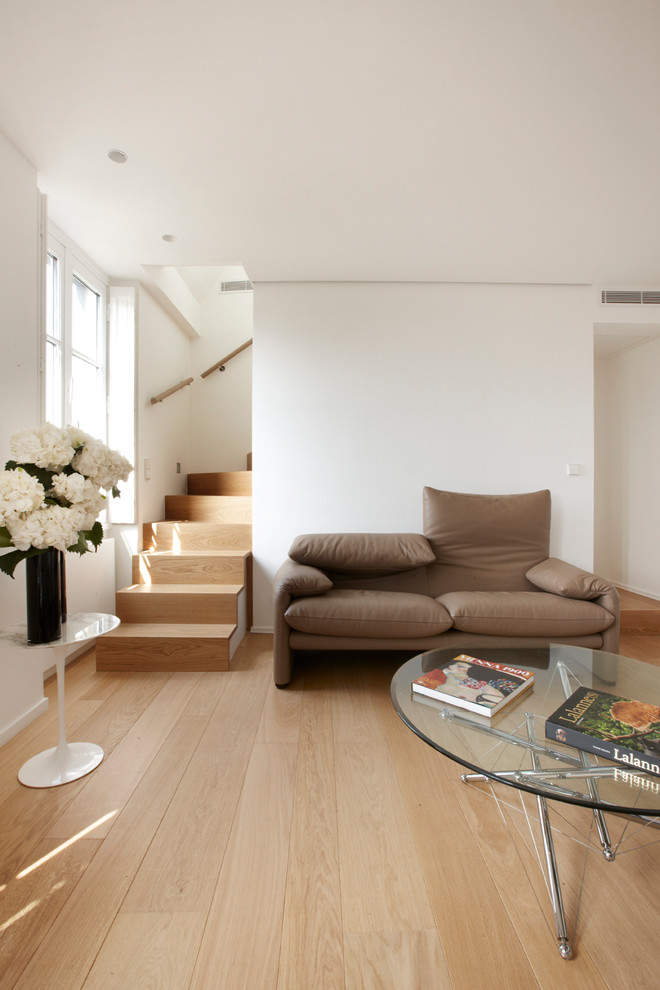 Ejemplo de sala de estar abierta contemporánea de tamaño medio sin televisor con paredes blancas y suelo de madera en tonos medios