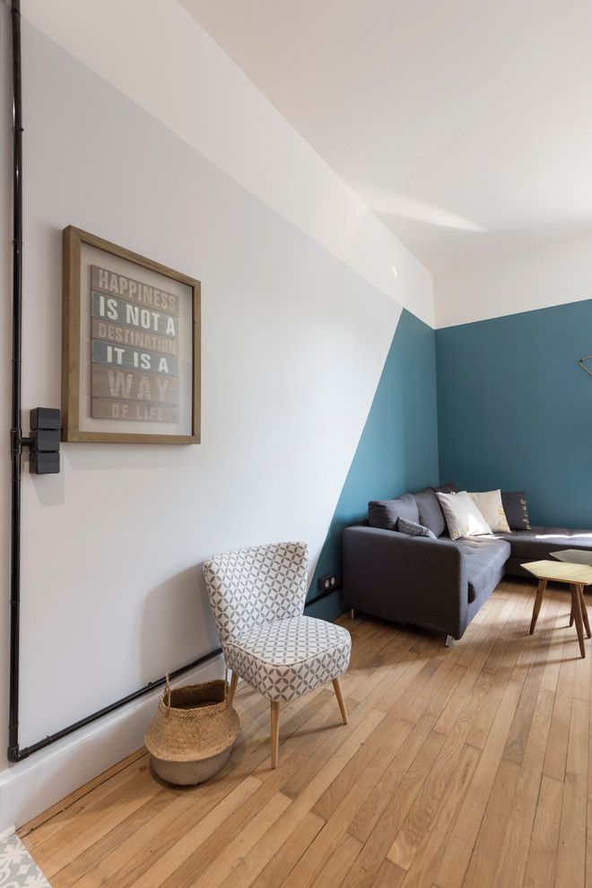 Cette image montre une salle de séjour vintage de taille moyenne et ouverte avec un mur bleu et parquet clair.