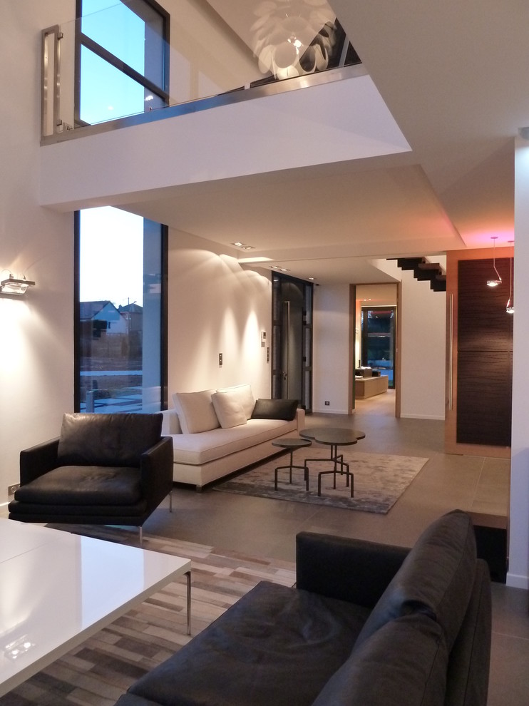 Exemple d'un grand salon tendance ouvert avec un mur blanc, un sol en carrelage de céramique, un téléviseur dissimulé et un sol gris.