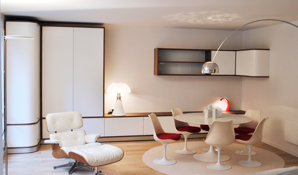 Cette image montre une grande salle de séjour design ouverte avec un mur blanc, parquet clair et aucun téléviseur.