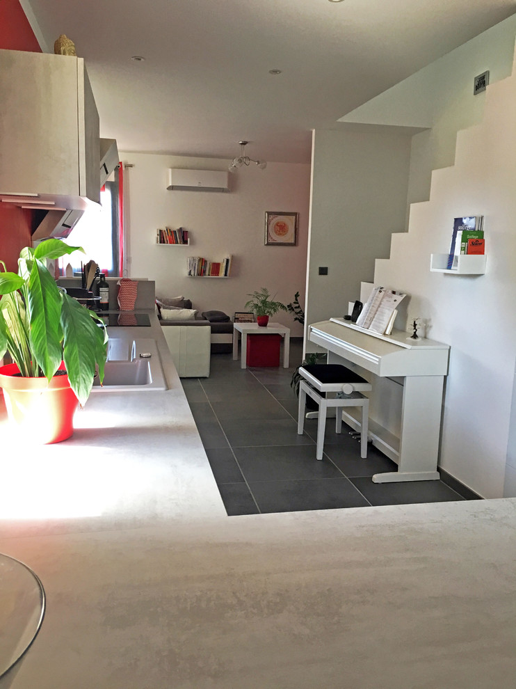 Exemple d'une salle de séjour tendance de taille moyenne et ouverte avec une salle de musique, aucune cheminée, un mur rouge et un sol gris.