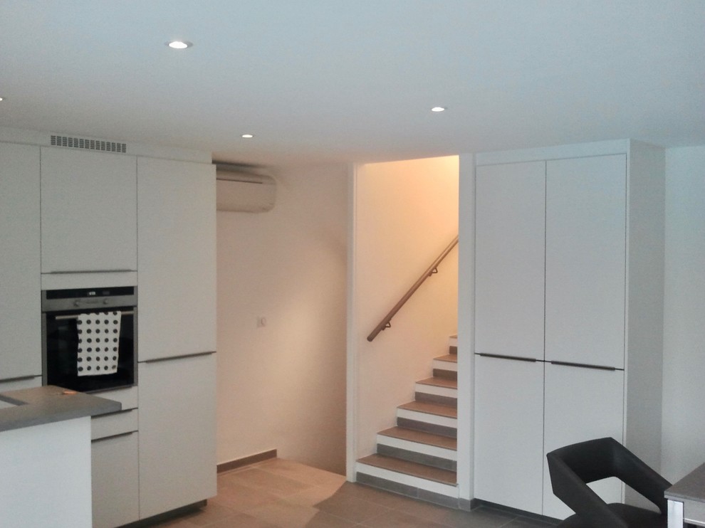 Mittelgroßes, Offenes Modernes Wohnzimmer ohne Kamin mit Hausbar, weißer Wandfarbe, Keramikboden und TV-Wand in Marseille