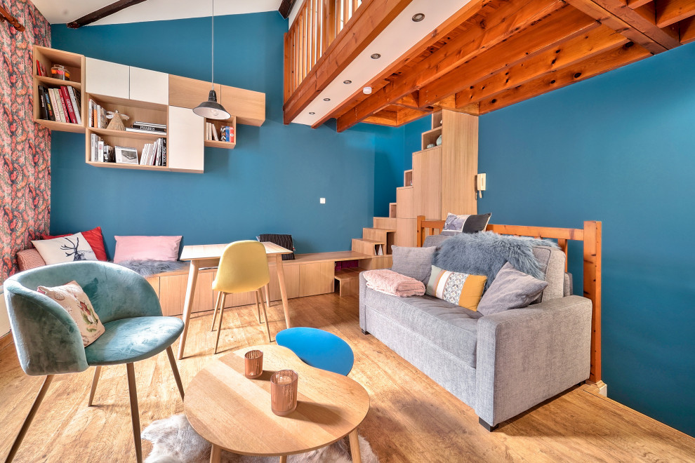 Réalisation d'une salle de séjour design avec un mur bleu, un sol en bois brun, un sol marron et un plafond voûté.