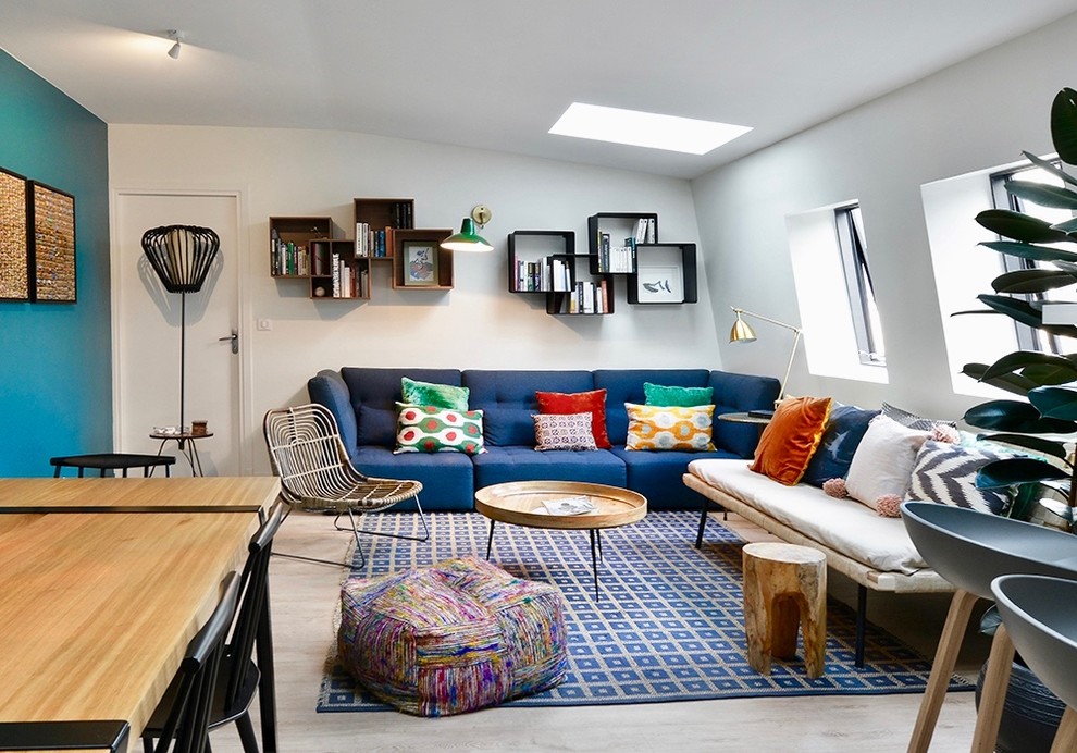 Immagine di un piccolo soggiorno design aperto con libreria, pareti bianche, parquet chiaro, nessun camino, nessuna TV e pavimento beige
