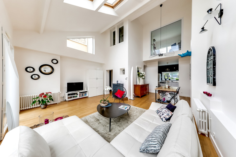 Aménagement d'une salle de séjour contemporaine de taille moyenne et ouverte avec un mur blanc, parquet clair, un téléviseur indépendant et un sol beige.