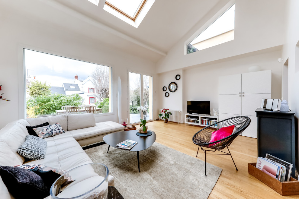 Exemple d'une salle de séjour tendance de taille moyenne et ouverte avec un mur blanc, parquet clair, un téléviseur indépendant et un sol beige.