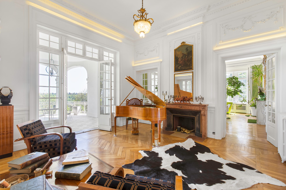 Photo of a traditional games room in Lyon with a music area, white walls, medium hardwood flooring, a standard fireplace and brown floors.