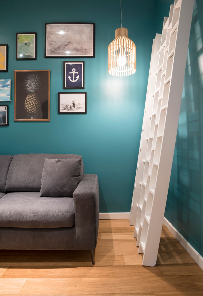 Aménagement d'une salle de séjour contemporaine avec un mur bleu et parquet clair.