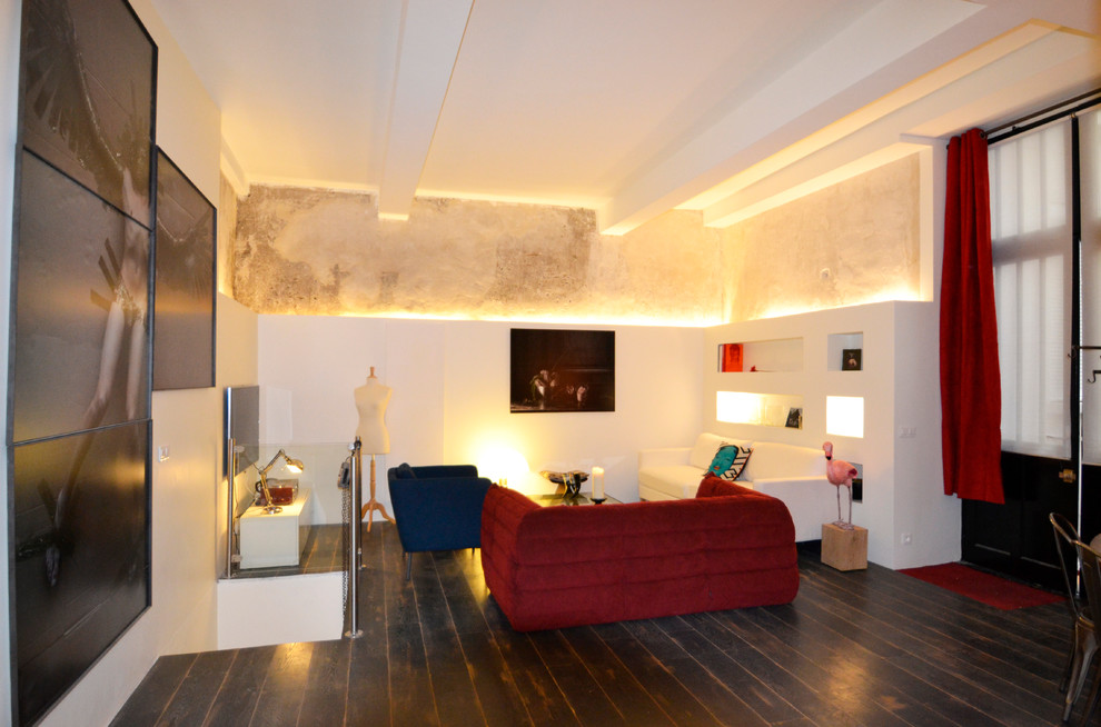 Ejemplo de sala de estar abierta contemporánea de tamaño medio con paredes beige, suelo de madera oscura, televisor colgado en la pared y suelo marrón