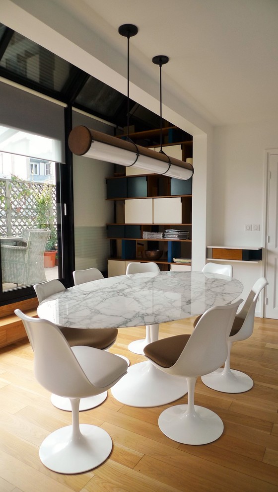 Foto di una sala da pranzo contemporanea di medie dimensioni con pareti bianche, pavimento in compensato, pavimento marrone e nessun camino