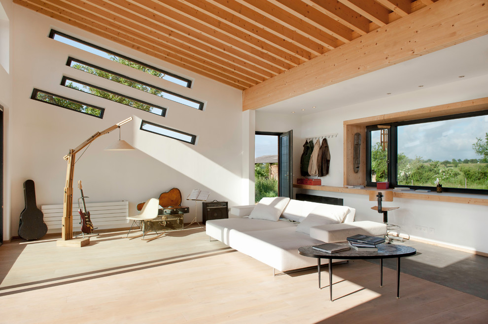 Inspiration pour une grande salle de séjour design ouverte avec un mur blanc, parquet foncé, aucun téléviseur et un sol marron.