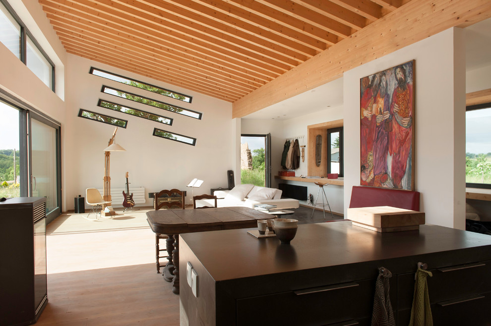 Großes, Fernseherloses, Offenes Modernes Wohnzimmer mit weißer Wandfarbe, dunklem Holzboden und braunem Boden in Lyon