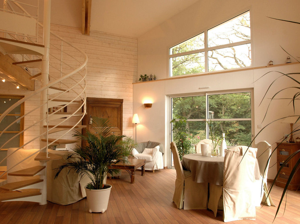 Aménagement d'une grande salle de séjour moderne ouverte avec un mur blanc, un sol en bois brun et aucune cheminée.