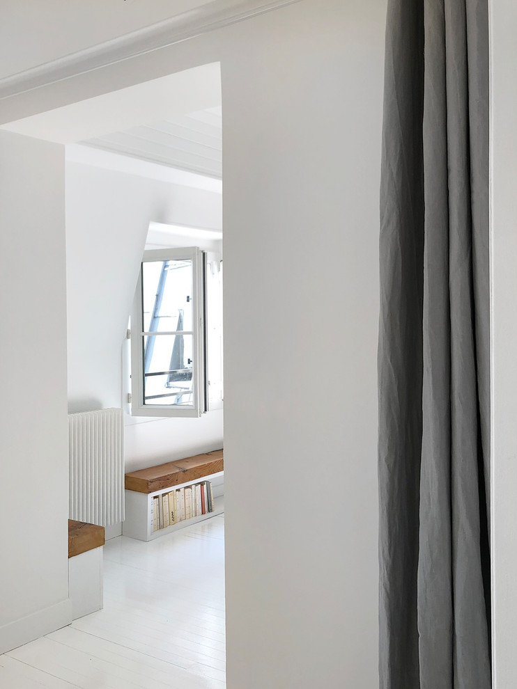 パリにあるお手頃価格の広いコンテンポラリースタイルのおしゃれなオープンリビング (ライブラリー、白い壁、塗装フローリング、標準型暖炉、レンガの暖炉まわり、白い床、テレビなし) の写真