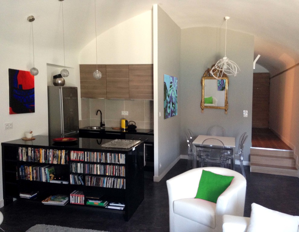 На фото: маленькая открытая гостиная комната в современном стиле с с книжными шкафами и полками, серыми стенами, полом из линолеума, отдельно стоящим телевизором и черным полом для на участке и в саду с