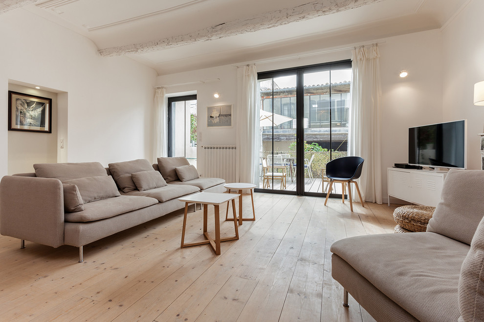 Mittelgroßes, Offenes Modernes Wohnzimmer mit weißer Wandfarbe, hellem Holzboden und freistehendem TV in Montpellier